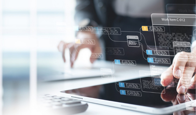 Fingers interacting with a digital tablet displaying abstract holographic data flowcharts