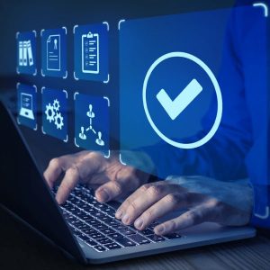 Hands typing on a laptop with overlay of a glowing checkmark icon and data symbols indicating real-time validation and QA