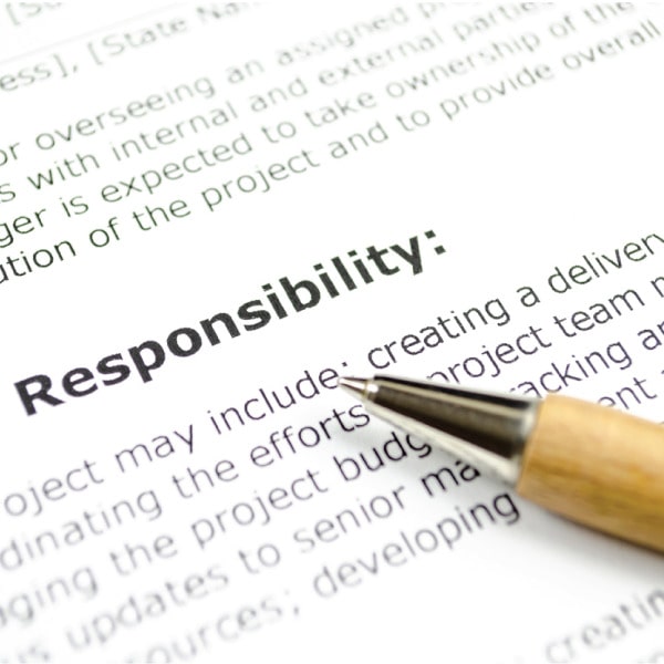 Pen resting on a printed document with the word “Responsibility” in focus, representing formal application review