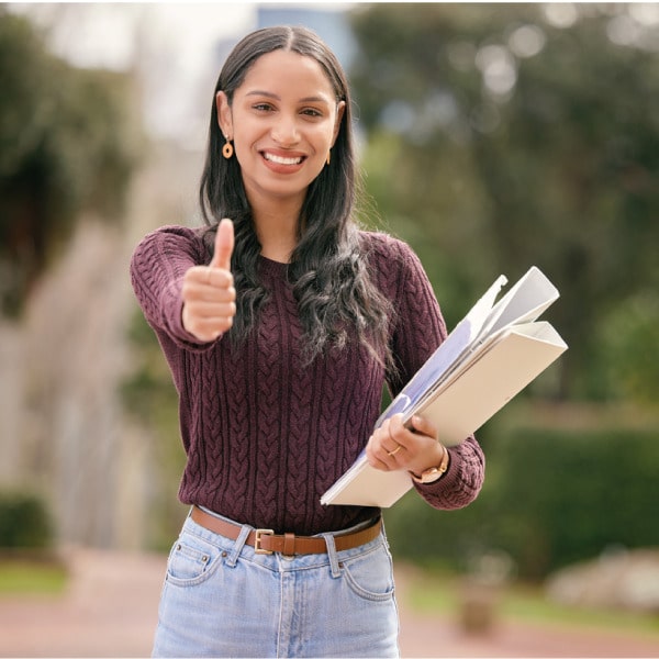 Smiling woman giving a thumbs-up while holding documents, symbolizing successful manufacturing approval process
