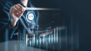 A person interacts with a digital interface displaying KPI metrics, graphs, and charts.